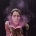 woman blowing smoke on her both hands