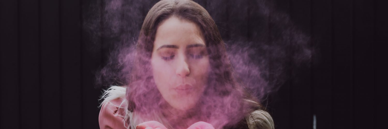 woman blowing smoke on her both hands