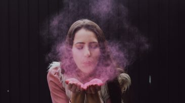 woman blowing smoke on her both hands
